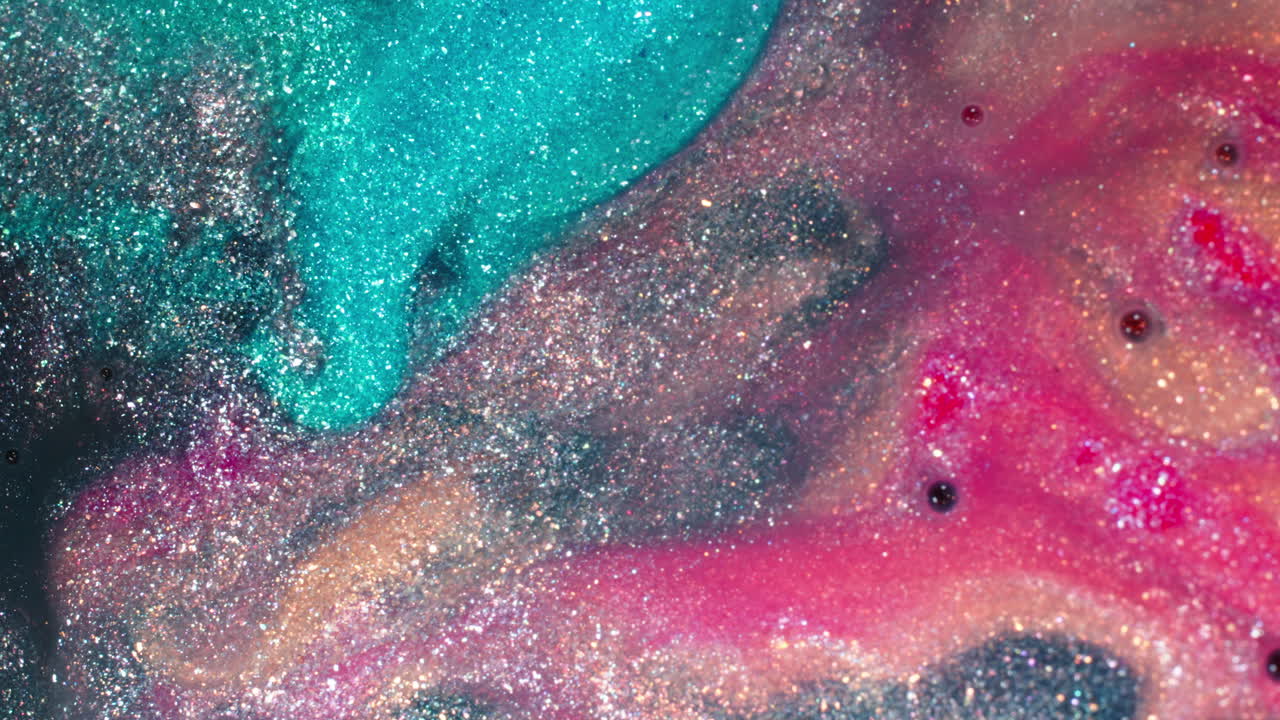 Swirling colors and glitter mix in vibrant patterns, creating a mesmerizing close-up of liquid art