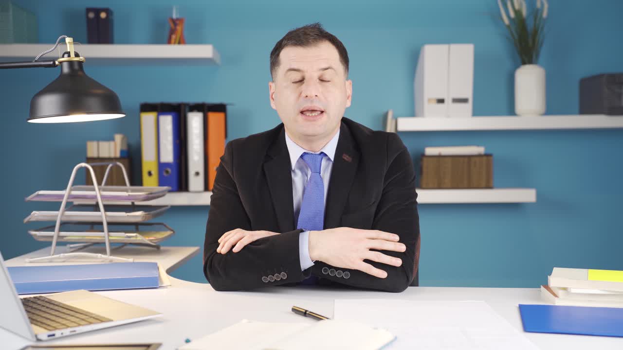 진지한 사업가가 사무실에서 카메라를 쳐다보며 이야기하고 있습니다.