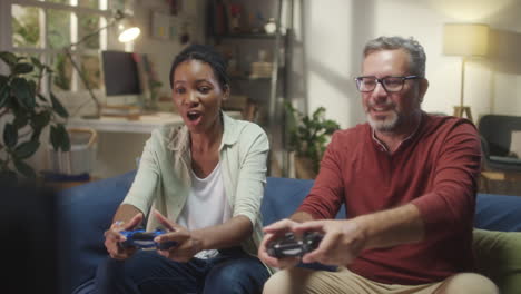 happy couple or friends playing video games at home