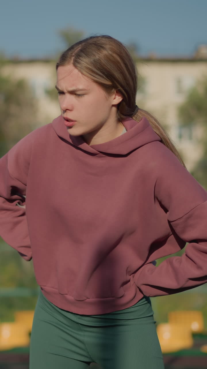 niñas jóvenes realizando ejercicios al aire libre con un fondo borroso de personas en la distancia, involucradas en actividades de fitness en la cancha deportiva, disfrutando de la luz del sol y el ejercicio