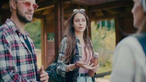 young woman holding bottle and talking with friends