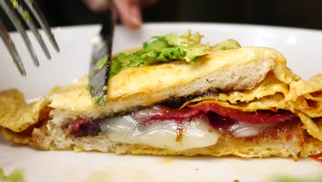 close-up of a delicious breakfast sandwich with avocado, ham, and cheese