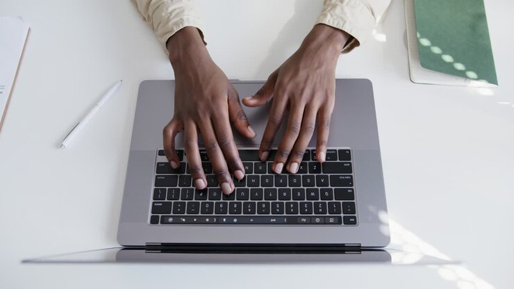 Person, die auf dem Laptop eingibt
