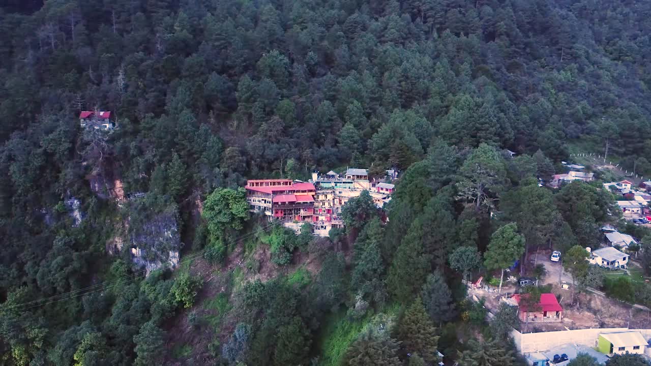 vista aérea de un avión no tripulado de la montaña con cabañas en medio de un bosque exuberante en oaxaca, méxico