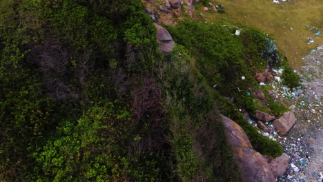 dolly aéreo de ojo de pájaro a la derecha del paisaje que revela la basura acumulada en la playa