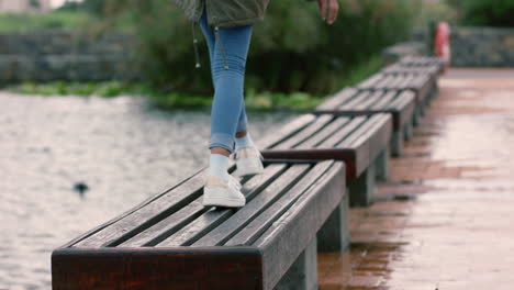 Nahaufnahme-Der-Beine-Einer-Frau,-Die-Im-Park-Spaziert,-Auf-Bänke-Springt-Und-Spielerischen-Spaß-Im-Freien-Genießt.-Glückliches-Teenager-Mädchen-Mit-Weißen-Schuhen