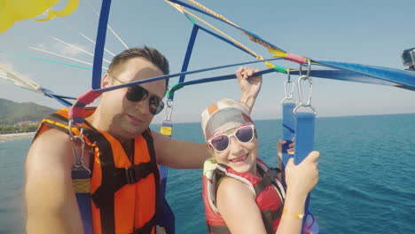 dad and daughter are flying on parasailing a father takes a selfie with a girl an active vacation wi