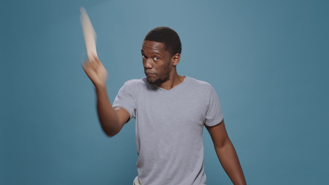 Aggressive upset rebel raising paddle at camera to fight