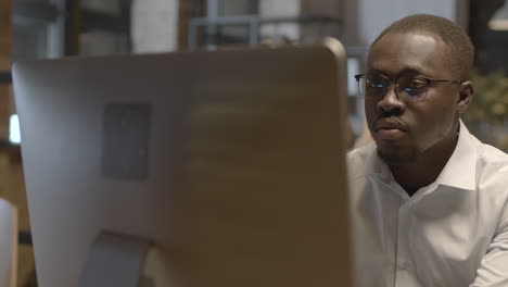 close up of a serious american employee working on computer in the office