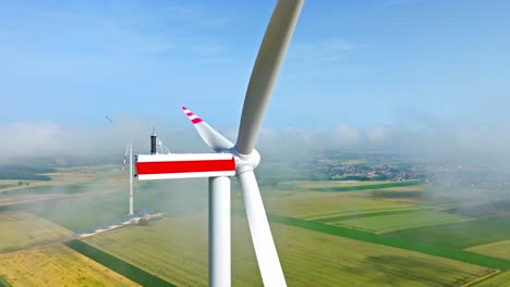 motionless wind turbines in fog clouds on a sunny morning