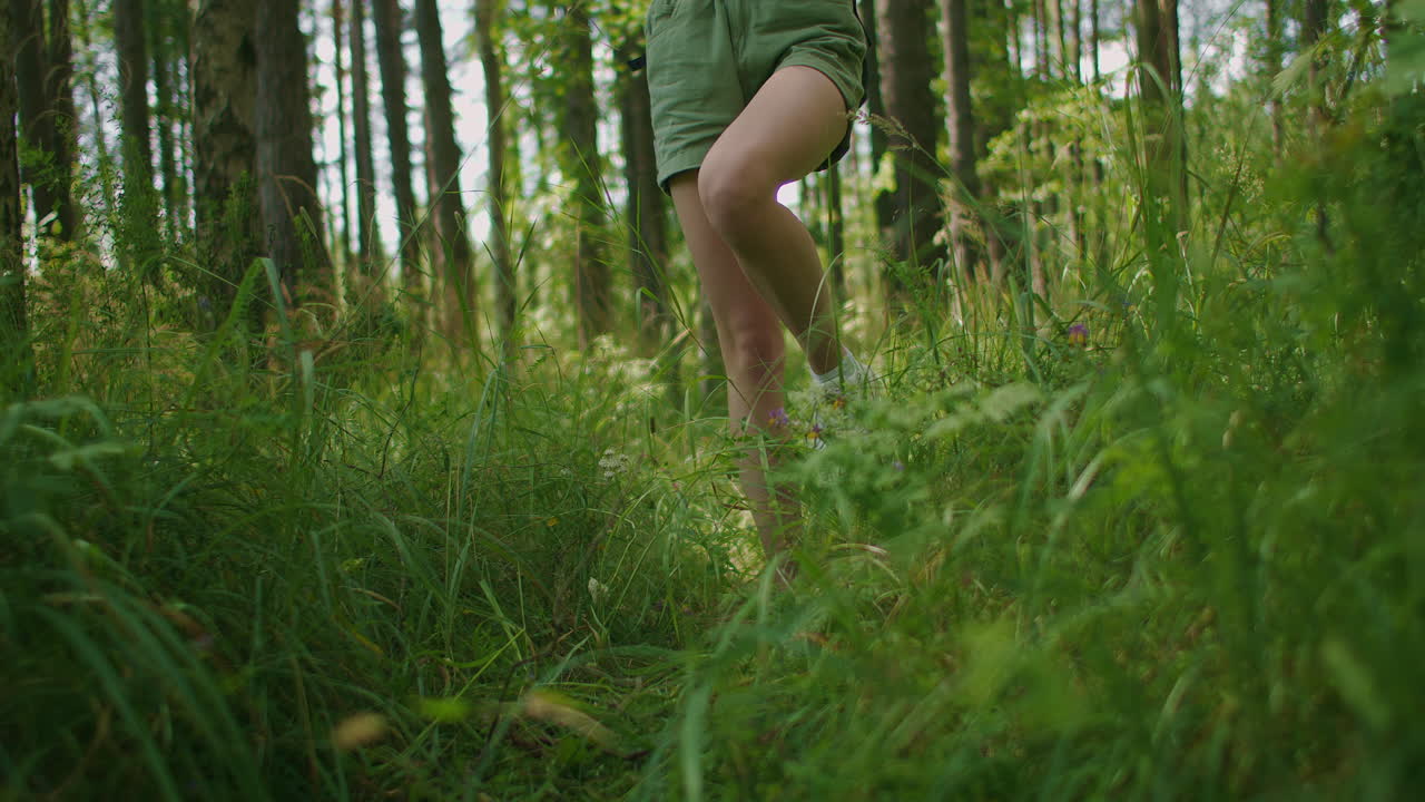 Legs going close-up on the grass in the forest