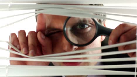 distrustful businessman using magnifying glass