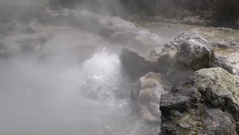 slow motion closeup of a volcanic spring spilling out hot water