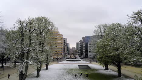 three sportive men running in the urban city park on a snowy winter day - aerial view