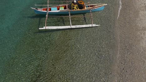 Slowmo-Flugvorbeiflug-über-Einem-Auslegerboot-Eines-Fischers-Am-Ufer