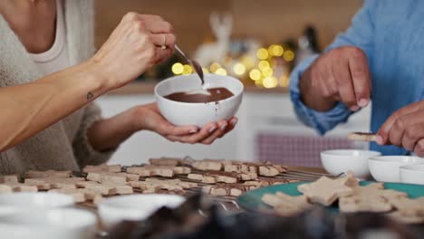 Nicht-Wiederzuerkennendes-Paar-Mit-Mehreren-Ethnien,-Das-Zu-Weihnachten-Zu-Hause-Süße-Kekse-Dekoriert.