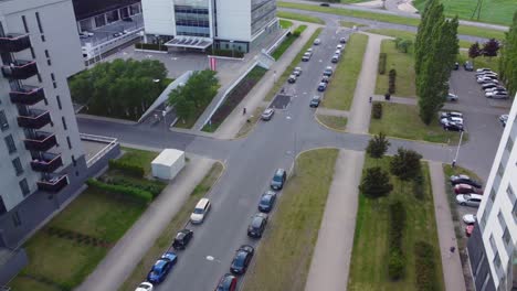 volando a través de edificios residenciales de varios pisos con coches estacionados en la calle entre ellos