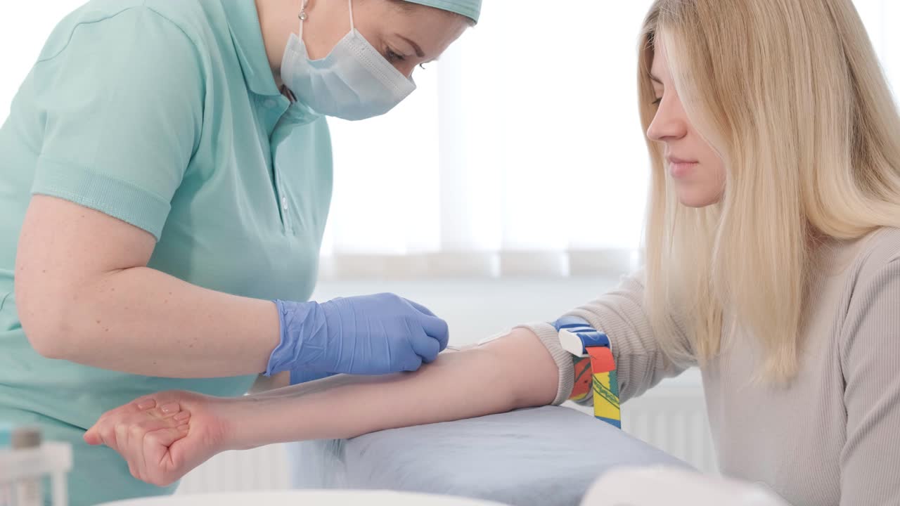 A doctor in a hospital gently draws blood from a girl for diagnostic tests.