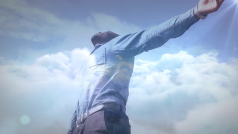 animación de luz brillante sobre el hombre con los brazos extendidos relajándose en la naturaleza contra el cielo azul