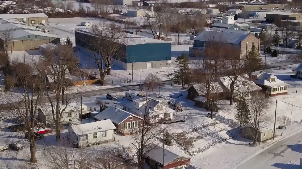 Drone view of the snowy settlement and a truck approaching