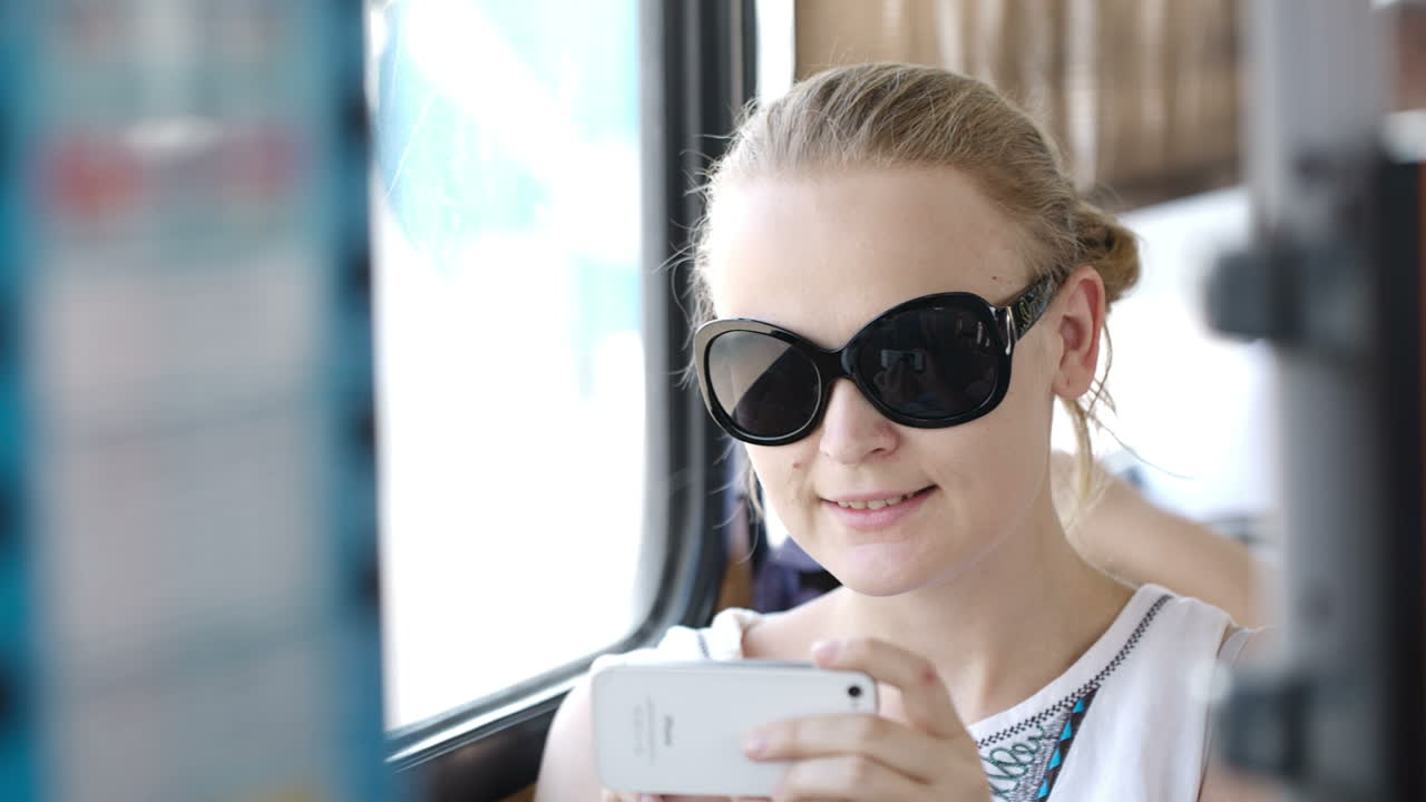 mujer tomando fotos en su móvil en un autobús