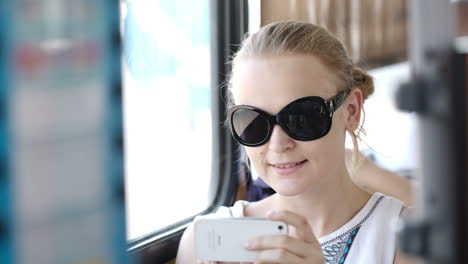 Frau-Fotografiert-Mit-Ihrem-Handy-In-Einem-Bus