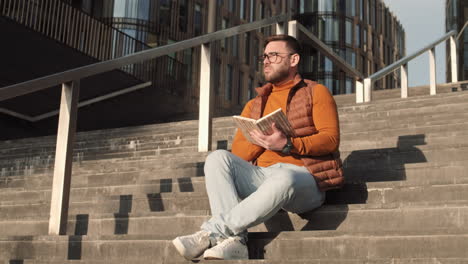 man reading on stairs outdoors