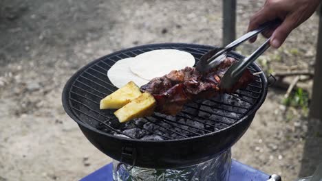 turning around the chicken sticks on the small bbq at the streets of costa rica