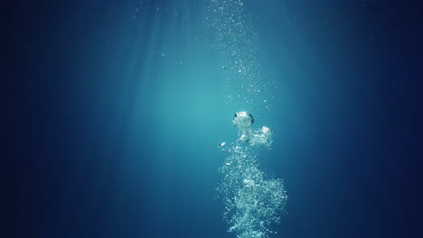 underwater sunlight beams shining from above coming through the deep crystal clear blue water causing a beautiful water lighting reflections curtain with air bubbles rising up to the surface