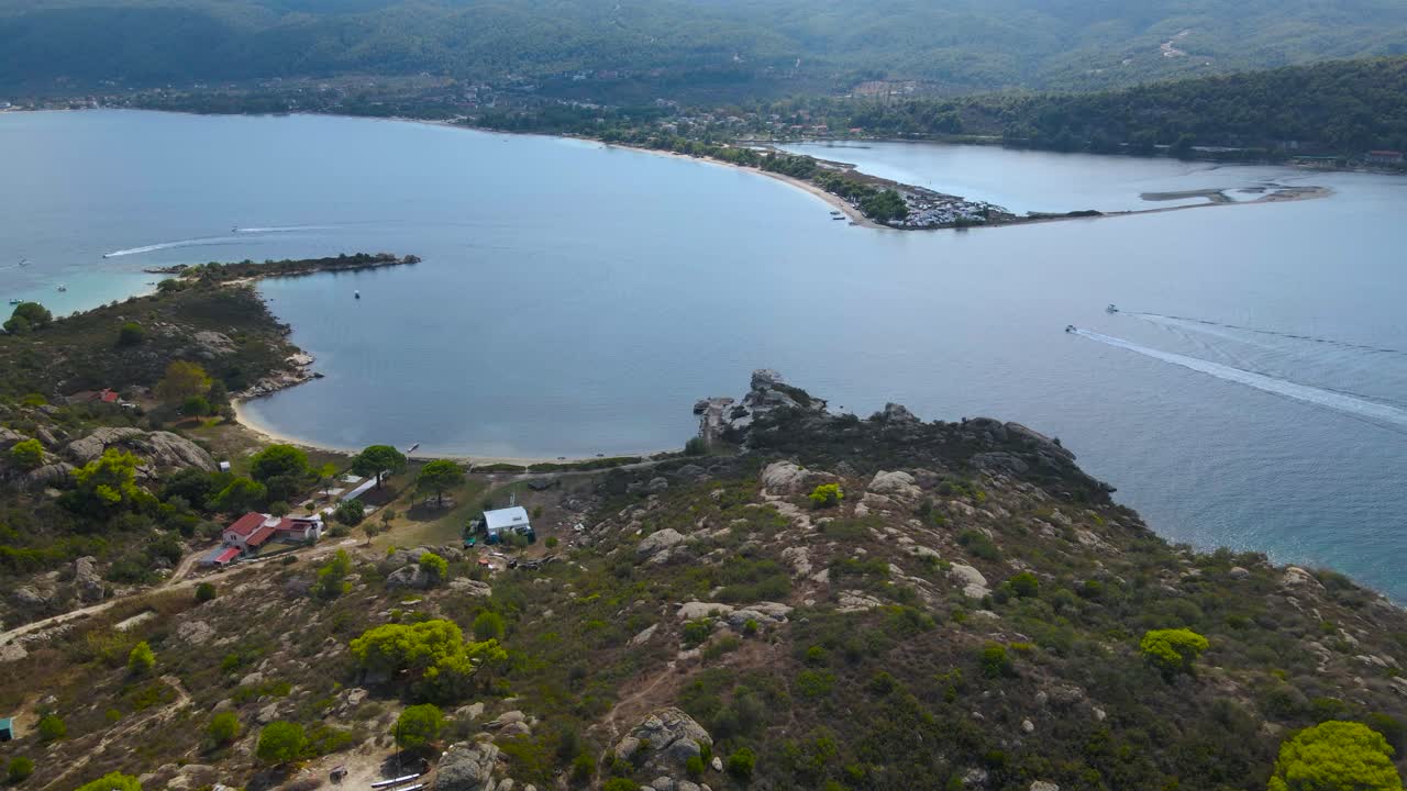 clip de dron de 4k que avanza lentamente sobre una isla tropical con barcos a lo lejos en la bahía de vourvourou, en chalkidiki, norte de grecia