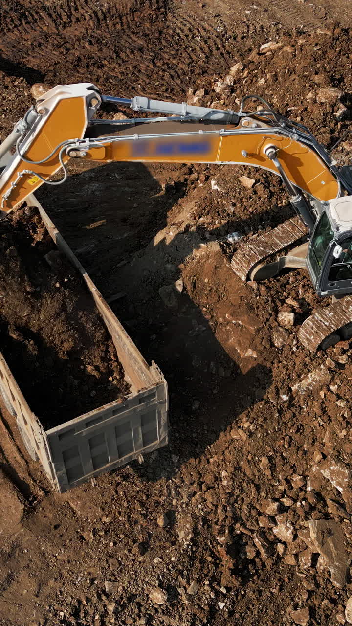 Excavator and Dump Truck Working on Construction Site