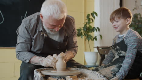 grandfather and grandchild making pottery together