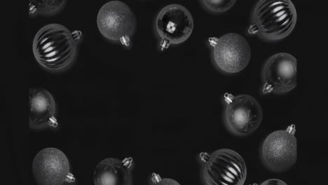 Animation-of-christmas-baubles-over-black-background