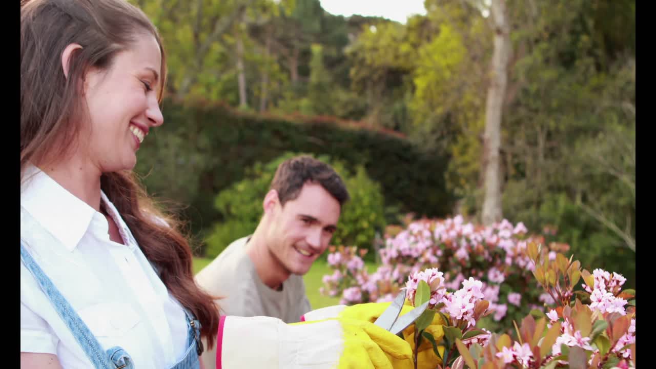 젊은 부부가 꽃을 자르고 있습니다.