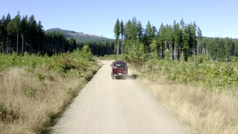 vw van vintage van driving through forest aerial view 4k drone