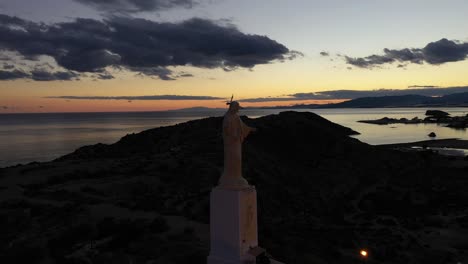 Imágenes-Aéreas-De-Una-Estatua-Cerca-Del-Mar-En-El-Sur-De-España-Al-Atardecer