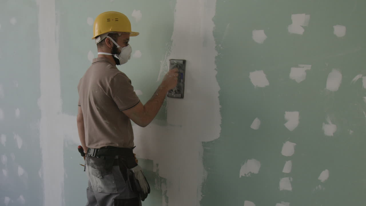 Construction worker repairing drywall