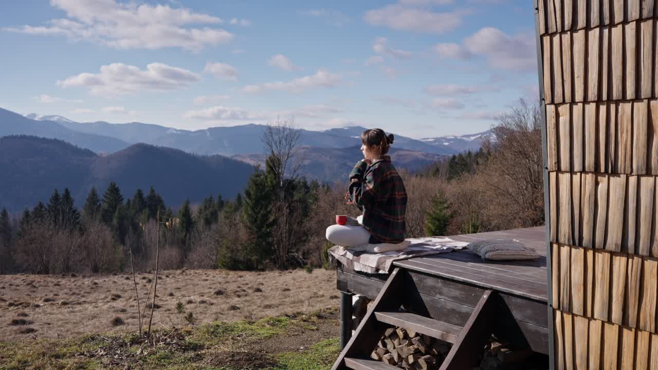 Woman Relaxing on Cabin Deck in Mountains