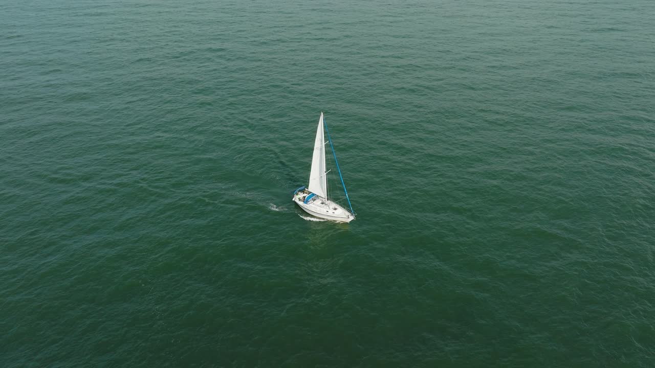 vista aérea de un velero blanco en el tranquilo mar báltico, yate de vela blanco en medio del mar sin límites, día soleado de verano, gran ojo de pájaro hecho disparo, inclinado hacia abajo