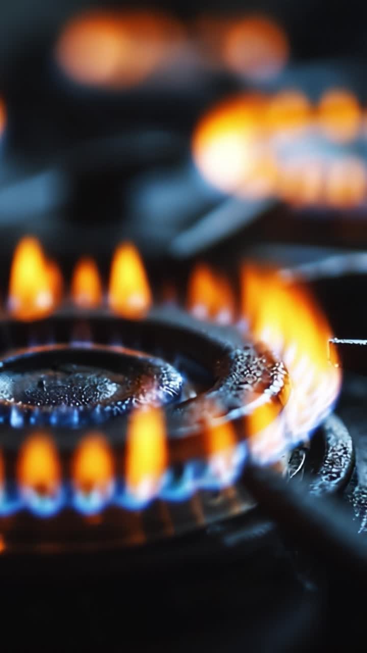 A Close-Up View of Gas Burner Flames Dancing on a Stove Highlighting the Colorful Blue and Orange Flames in an Intimate Kitchen Setting