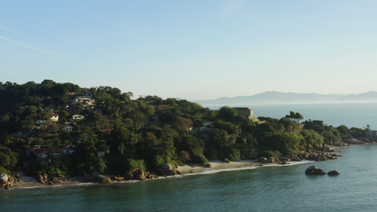 vista aérea que rodea una fantástica costa rocosa al atardecer, jurere internacional, florianópolis, santa catarina, brasil