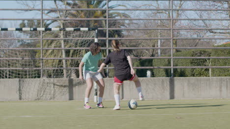 teenager girls playing soccer outdoors