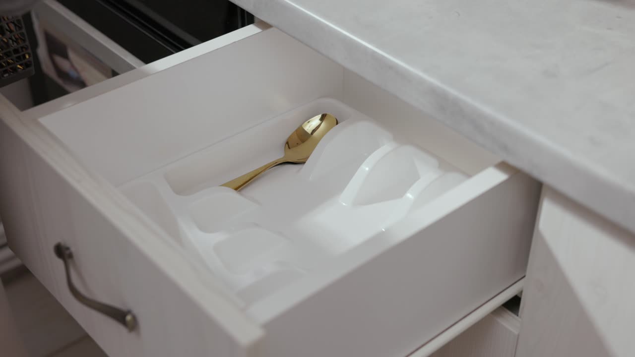 Cropped View Of A Person Arranging Tableware Inside The Drawer