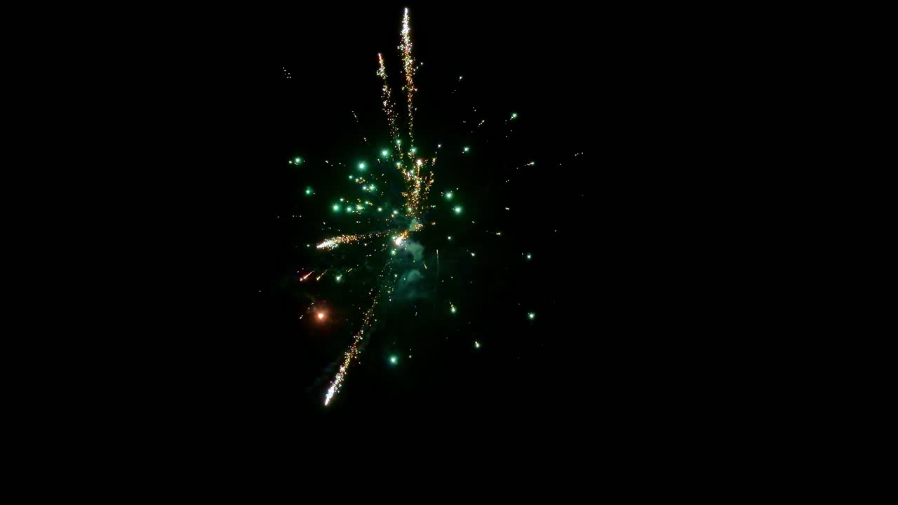 Colorful fireworks exploding in dark night sky creating festive celebration light at New Year's Eve