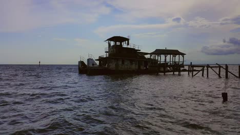 Semi-sunken-push-boat-docked-in-a-river-on-a-cloudy-day