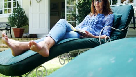 Mature-woman-reading-a-book-in-the-garden-4k