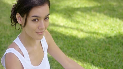 Serene-young-woman-meditating-on-a-green-lawn