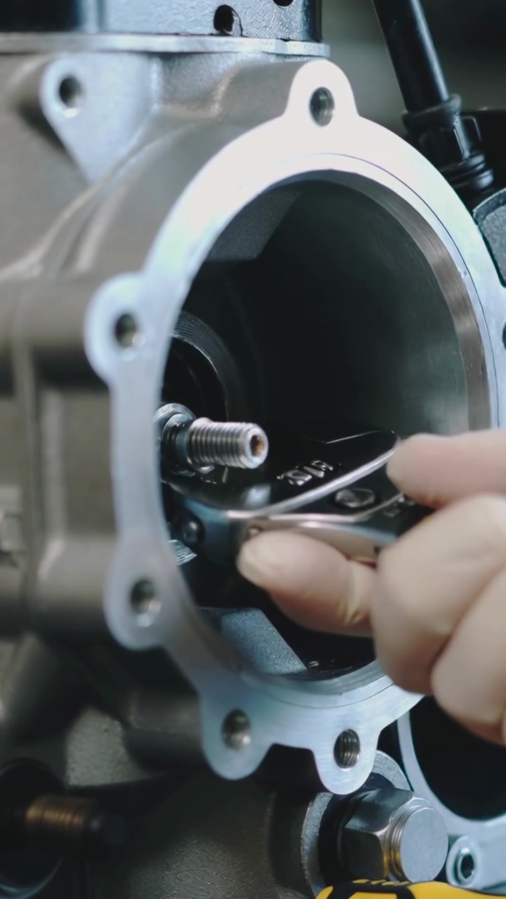 Vertical video: Driver entering, tech hand turning screw then wrenching nut on bore at bench to fix