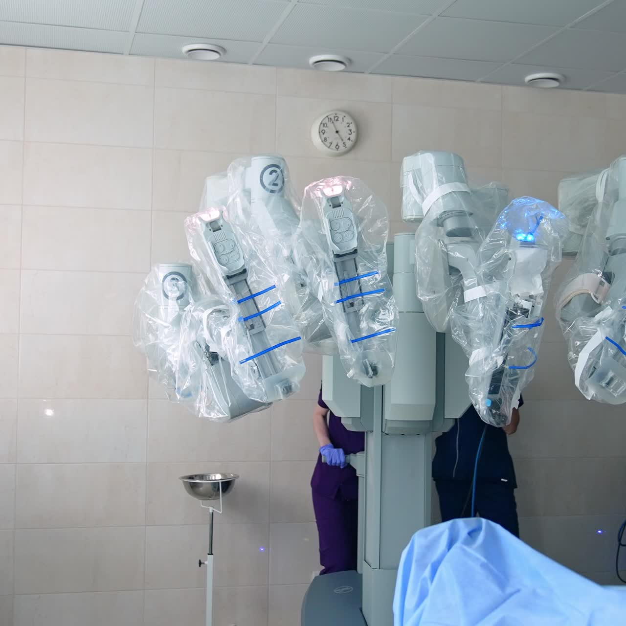 Amazing technological equipment for minimal invasive operations. Da Vinci robot in modern surgery room. Medics standing behind the machine