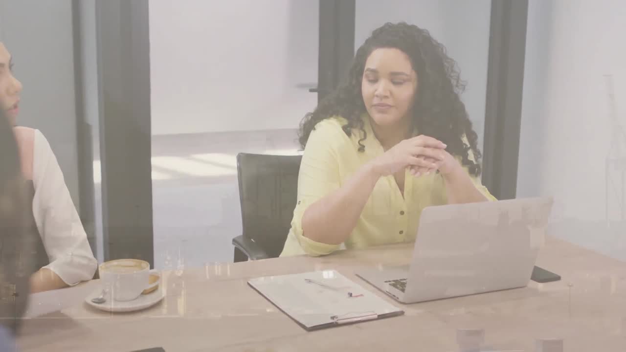 Animation of cityscape over diverse business people in meeting in office